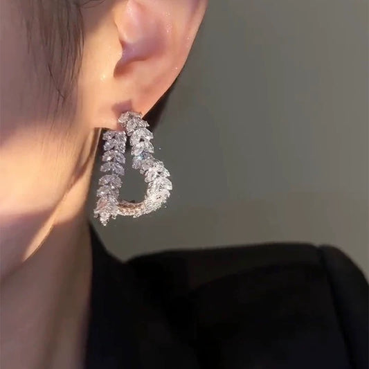 Model wearing Wheat Cross Heart Earrings showcasing intersecting wheat design and clip-on fit