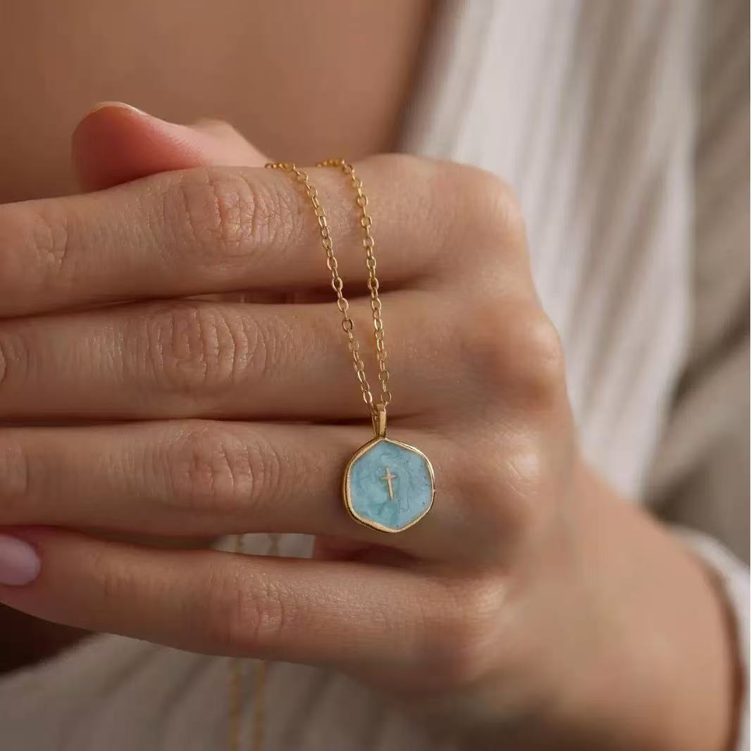 Close-up of electroplated enamel mini cross pendant necklace
