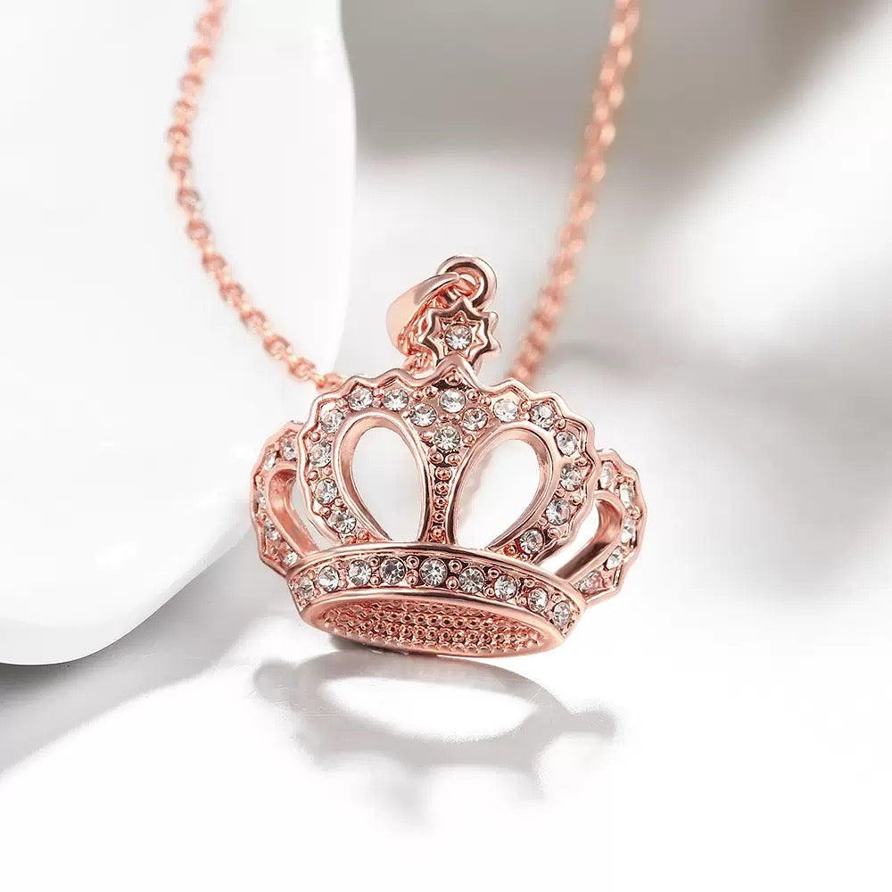 Close-up of rose gold crown necklace with sparkling stones